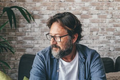 Thoughtful Serious Mature Man Sitting On Sofa Alone At Home Adult Male In Deep Thoughts At
