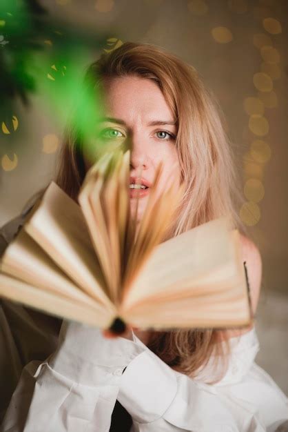 Premium Photo Young Woman Reading A Book While Sitting On Her Bed At