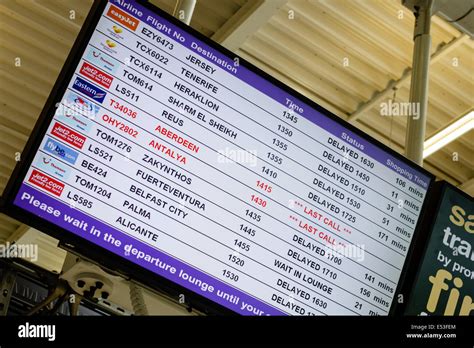 Departures display showing flight delays at Newcastle Airport UK during ...