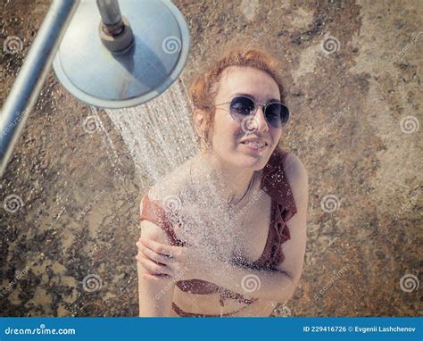 The Girl In Sunglasses And A Bikini Washes Under The Shower Outdoors Beach Shower Stock Photo