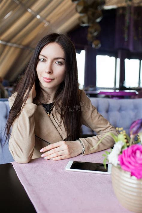 Close Up Sitting In A Cafe Restaurant Waiting For Her Order Beautiful Brunette With Phone In