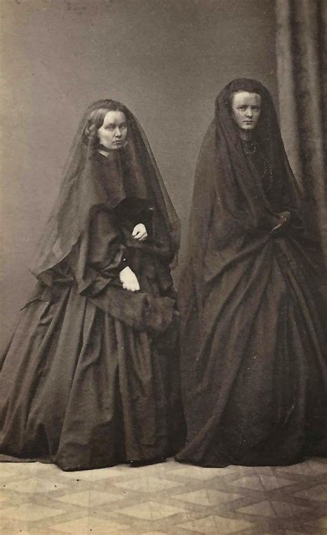 2 very young widows, dressed in full mourning with long veils