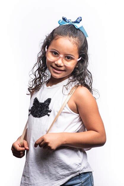 Retrato de una chica latina sonriente con gafas mirando a la cámara sobre un fondo blanco