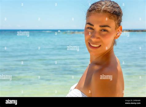 A Sun Kissed Beauty Basks In The Warm Glow Of Paradise Dressed In A Pristine White Bikini Her