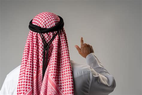 Back View Of Young Arab Man Standing On Gray Background Stock Photo