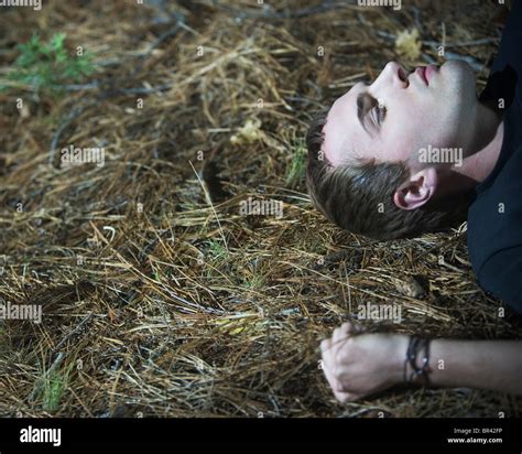 Head and arm of a young man lying on the ground outside Stock Photo - Alamy