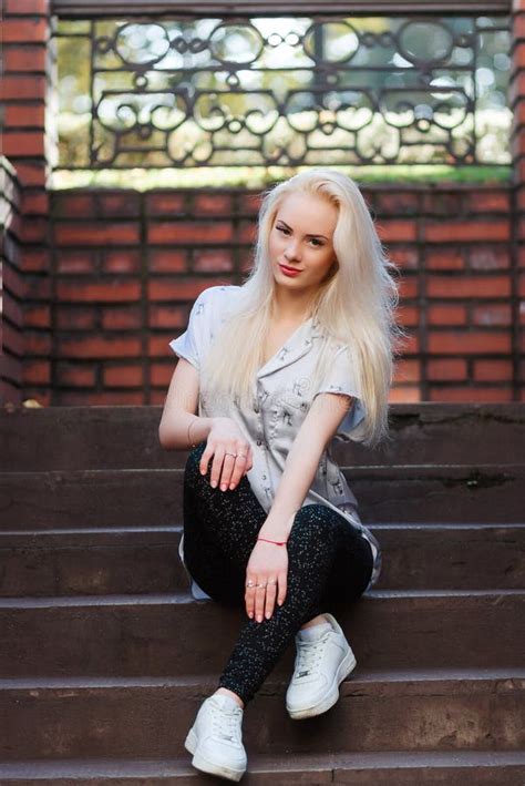 La Belle Jeune Fille Blonde Avec Un Joli Visage Et Un Beau Sourire Observe Le Portrait D Une