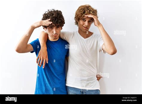 Un jeune couple gay debout ensemble sur un fond isolé inquiet et stressé au sujet d un problème