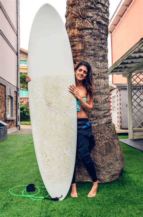 Jeune Femme De Surfer Avec La Planche De Surf De Baiser De Dessus Et De Bikini Photo Stock