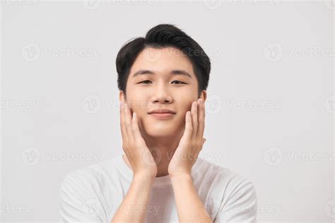 Happy and amazed asian young man touching his face, shocked with