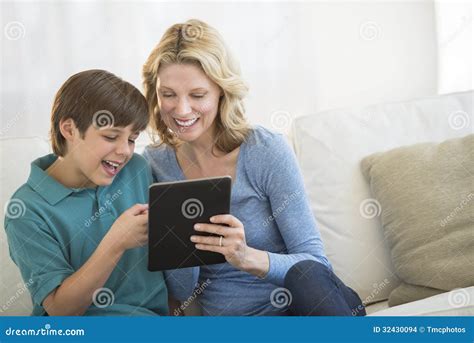 Woman And Son Using Digital Tablet Together On Sofa Stock Photo Image Of Digital Mature