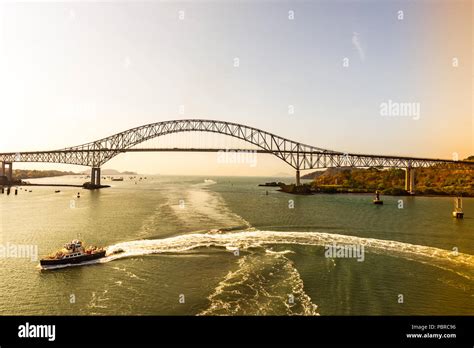 Un barco sale un arco en el agua antes de que el puente de las Américas