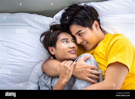 Heureux asiatique homosexuel gay hommes hommes couple mâle couché et embrassant sur le lit