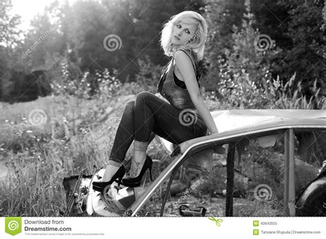 El Blonde Hermoso Elegante Atractivo De La Muchacha En Vaqueros En Zapatos Negros Se Sienta En