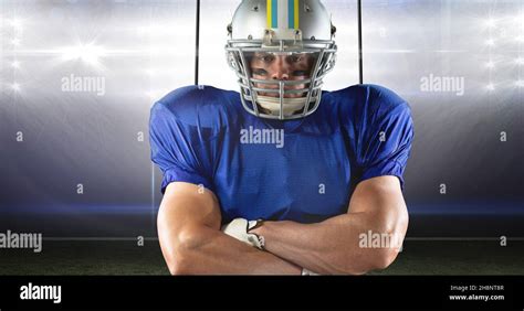 Portrait of confident young muscular male athlete wearing american football clothing at stadium ...