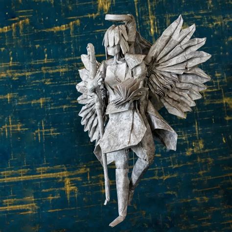 Origami Artist Folds A Stone Angel Figure Using A Single Sheet Of Paper