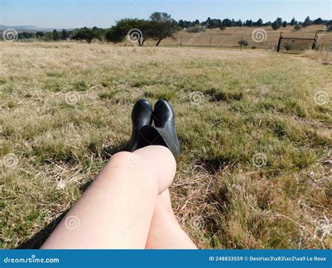 Caucasian Naked Legs Wearing Grey Shorts And Black Boots Legs Up One Foot On Knee Lying In A