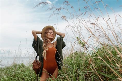 Premium Photo Sexy Blonde With A Braided Long Braid On Her Shoulder In A Red Bodysuit With A