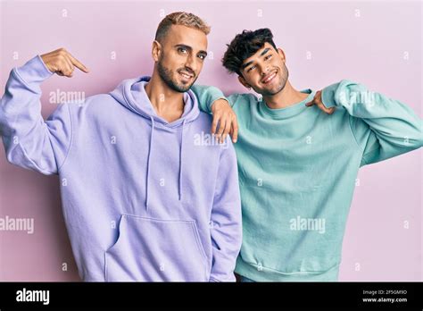 Homosexual Gay Couple Standing Together Wearing Casual Clothes Looking Confident With Smile On