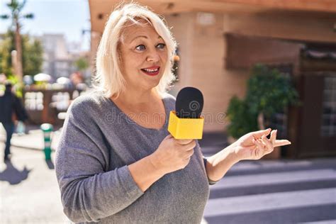 Middle Age Blonde Woman Reporter Working Using Microphone At Street Stock Photo Image Of