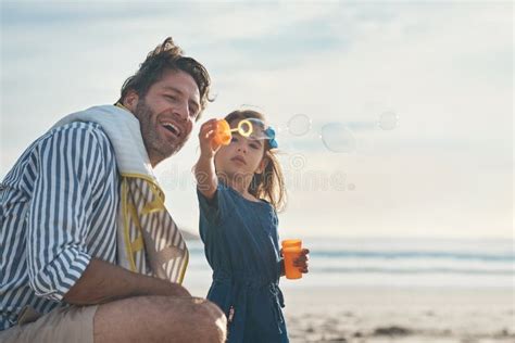 Dad Look What I Can Do A Playful Mature Father Blowing Bubbles With His Daughter During A Day