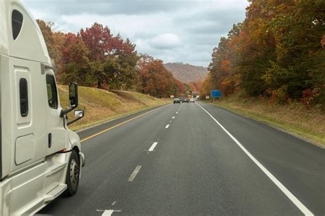 Un Coche Circula Por Una Carretera Con Rboles Al Fondo Foto Premium