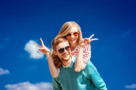 Pares Felices Que Abrazan Y Que Se Divierten Debajo Del Cielo Azul