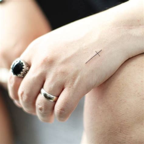 Minimalistic Cross Tattoo Placed On The Hand