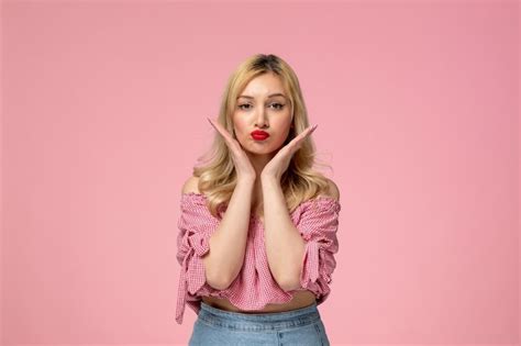 Jolie Fille Jolie Dame Blonde Portant Du Rouge à Lèvres En Chemisier Rose Faisant Un Visage