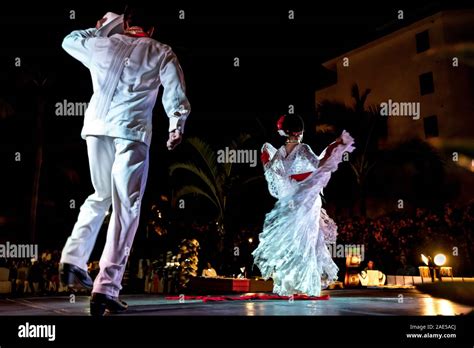 Two Mexican dancers in white costumes performing La Bamba, the ...