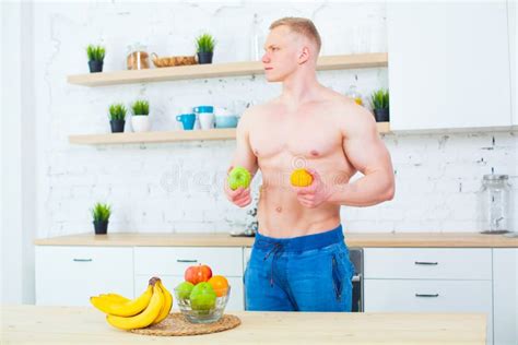 Muscular Man With A Naked Torso In The Kitchen With Fruit Concept Of Healthy Eating Athletic