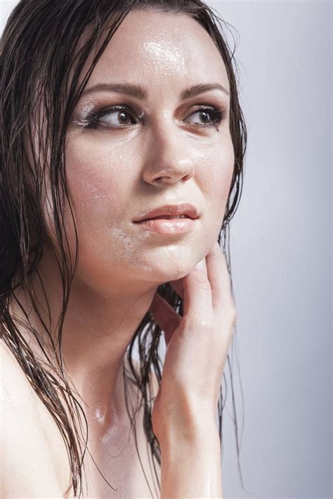 Portrait Of Caucasian Sensual Brunette Touching Neck And Showing Wet And Shining Skin And Wet