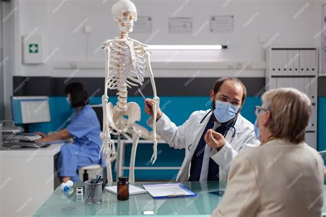 Medico Que Estrala Ossos - Médico explicando o esqueleto humano para idosos na visita de check-up ...