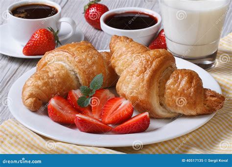 Круассаны с клубникой, кофе и молоком - здоровым завтраком Стоковое ...