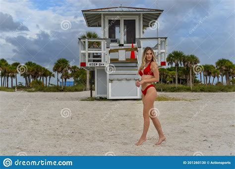 Lovely Blonde Bikini Model Posing Outdoors On A Caribbean Beach Near A Lifeguard Station Stock
