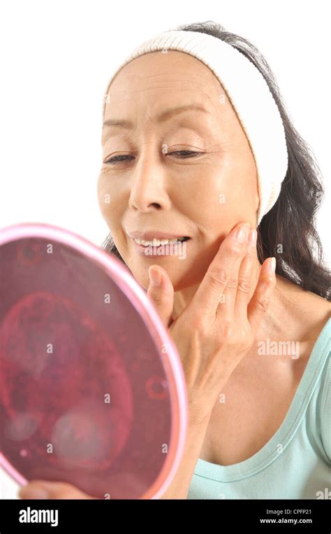 Senior Woman Looking Into Hand Mirror Stock Photo Alamy