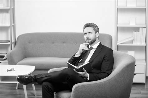 Premium Photo Mature Businessman In Suit Sit In Reading Office Making Notes In Notebook