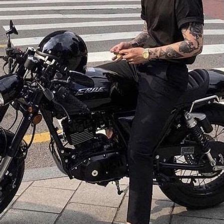 A Man Sitting On Top Of A Black Motorcycle