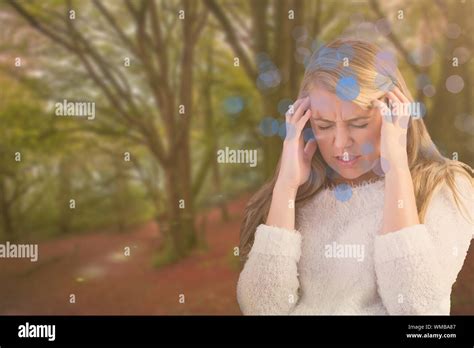 Pretty Blonde Getting A Headache On The Couch Against Peaceful Autumn Scene In Forest Stock