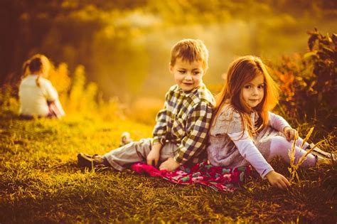 Les Enfants S assoient Côte à Côte Sur Un Plaid Photo Gratuite