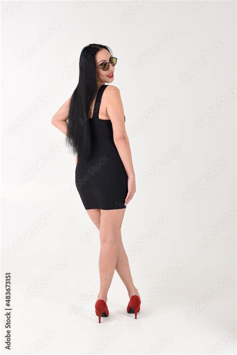 The Brunette Girl Is Beautiful And Stylish In A Black Dress And Dark Glasses With Her Feet In