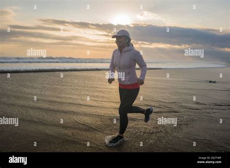 Fit And Attractive Mature Woman With Grey Hair Doing Beach Workout On Her S Running On The