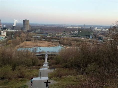 Two People Are Flying Kites In The Sky Near A River And Cityscape