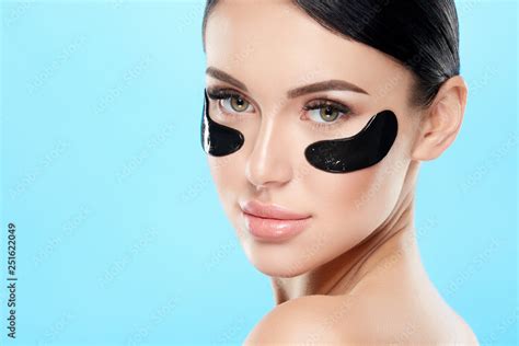 Attractive Girl With Nude Make Up And Naked Shoulders At Studio Background Black Eye Patches On