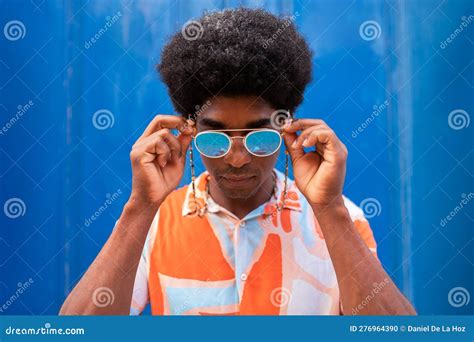 cool  confident young african american man putting  sunglasses