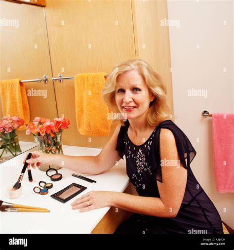 Portrait Of A Mature Woman Applying Make Up In The Bathroom Stock Photo Alamy