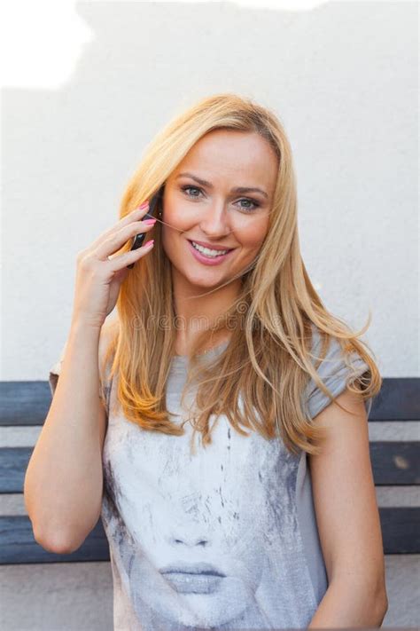Sensual Blonde Woman Sitting On Wooden Bench She Is Using Mobile Phone Stock Photo Image Of