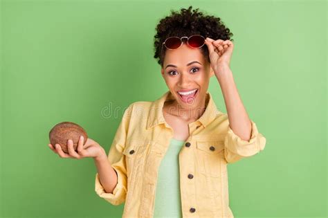Foto De Una Joven Dama De Brunette Impresionada Sostiene Coco Con Ropa De Ojos Camisa Amarilla