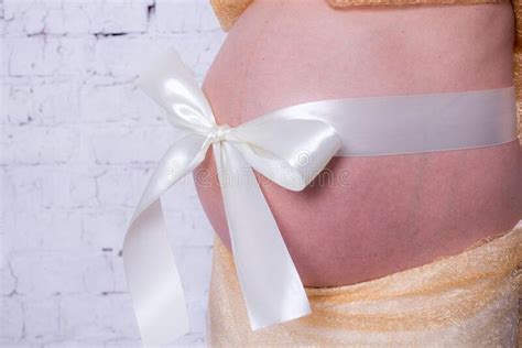 The Pregnant Womana S Naked Belly Is Decorated With A Bow Golden Skirt And Whi Sponsored