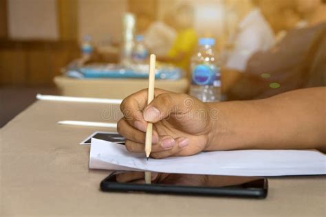 Mano Del Hombre Con La Escritura Del Lápiz En El Cuaderno Imagen de